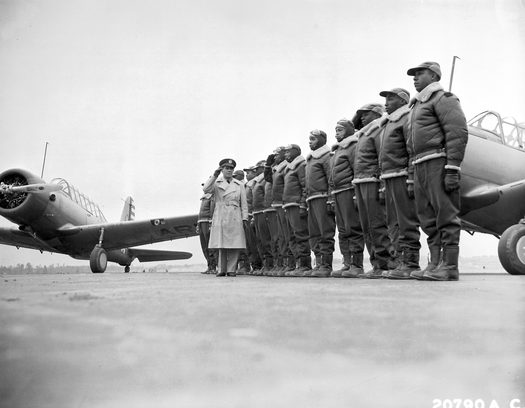 Major James A. Ellison returns the salute of Mac Ross during review of the first class of Tuskegee cadets on the flight line.