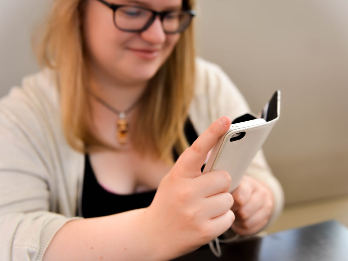 A real person holding and looking at a smartphone.