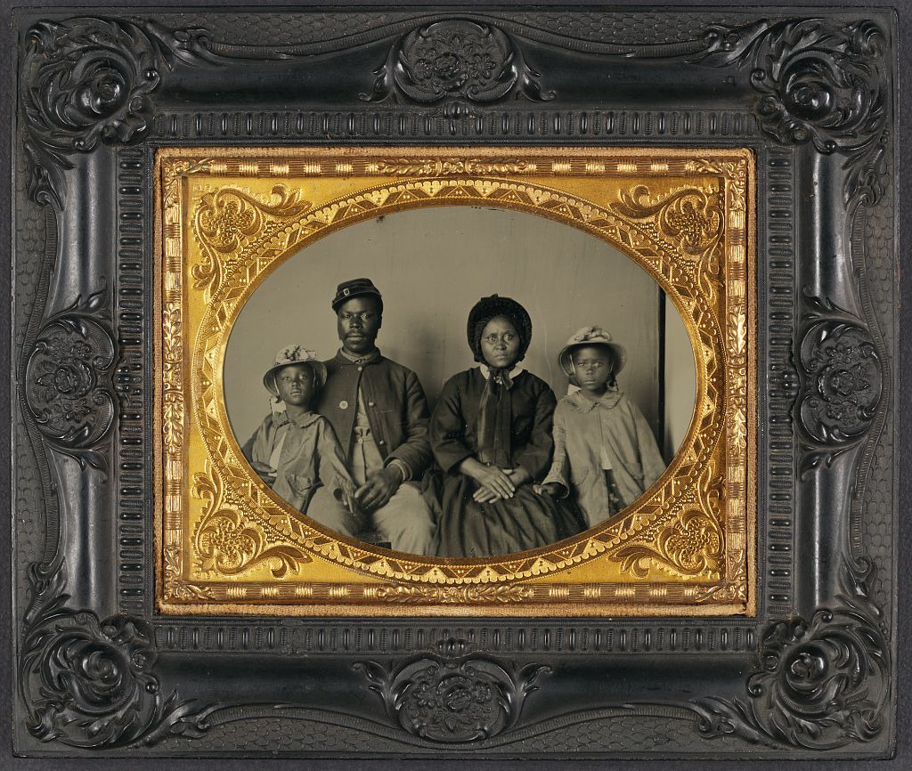 Framed Civil War-era portrait of an unidentified African American Union soldier with his wife and two daughters.
